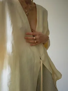 Gedetailleerd overzicht van crème ademend linnen kimono-vest met elegante strik