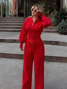 Modelo luciendo un conjunto de punto rojo con jersey de cremallera y pantalón ancho