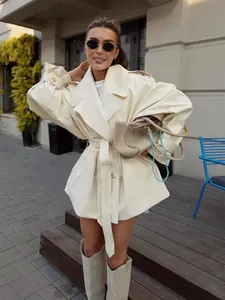Elegant cream-colored mid-length trench coat with waist belt and classic wide lapels