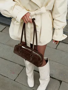 Close-up of a cream lapel trench coat with double-breasted buttons and adjustable waist belt.