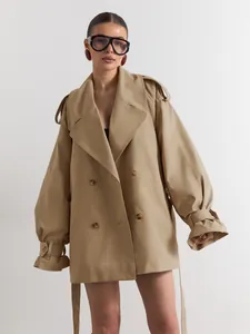 Stylish khaki double-breasted trench coat with wide lapels, oversized sleeves and belt.