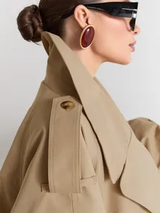 Detailed view of a stylish khaki trench coat featuring a sharp lapel and shoulder straps.