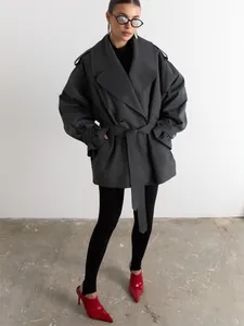 Fashionable dark gray oversized trench coat with belt and lapels on a model