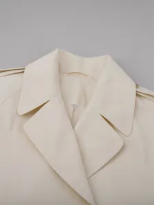 Close-up of the lapel and neckline detail on a cream double-breasted trench coat