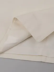 Macro view showing the high-quality stitching and interior lining of a cream trench coat.