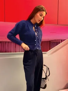 Λεπτομέρεια μπλε ναυτικής χνουδωτής ζακέτας με λευκά κουμπιά σε μοντέλο.