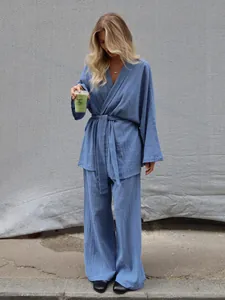 Detail view of a blue textured cotton pajama set with a tie-waist robe and wide-leg pants.