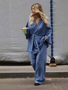 Full length view of a woman wearing a blue cotton crepe pajama set in a lifestyle setting