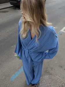 Detailed view of blue textured cotton pajama set with wrap tie waist in lifestyle setting