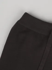 Detalle de la cintura elástica de canalé de un pantalón de punto marrón oscuro de talle alto