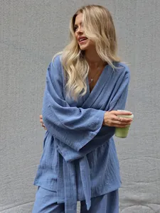 Close-up of soft blue crinkle cotton long sleeve pajama set on a smiling female model
