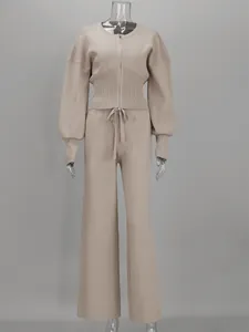 Vista frontal del conjunto de punto beige con top con cremallera y pantalones anchos.