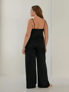 Vue arrière d'un ensemble de pyjama élégant en satin noir avec pantalon très large