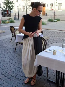 Jupe longue tulipe plissée élégante avec design asymétrique drapé dans un café