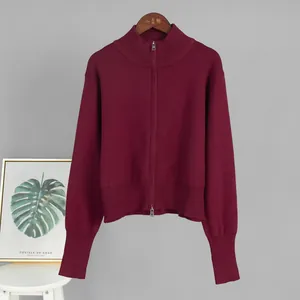 Close-up of wine red knitted cardigan featuring a double-ended zipper and ribbed cuffs.