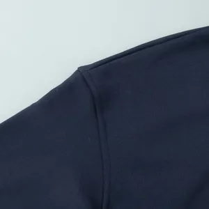 Macro view of high-quality shoulder seam stitching on dark navy cotton sweatshirt