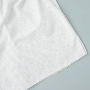 Close-up detail showing the white semi-transparent textured fabric of this beachwear set.