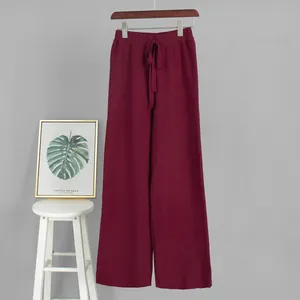 Full view of burgundy knitted wide-leg pants showing texture and drawstring waist detail