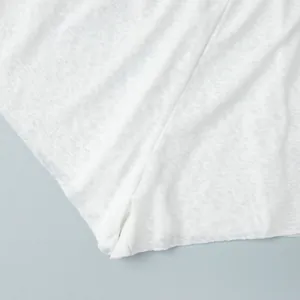 Close-up macro shot showing the sheer texture of white breathable beachwear fabric