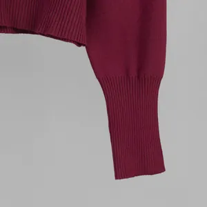 Close-up of burgundy ribbed cuff on a slim knit sweater showing high-quality texture