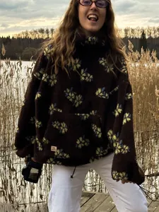 Detail of women's brown floral polar fleece hoodie in an outdoor casual setting