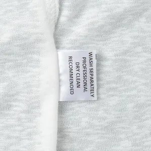 Detailed close-up showing the professional dry clean care label on white beachwear robe