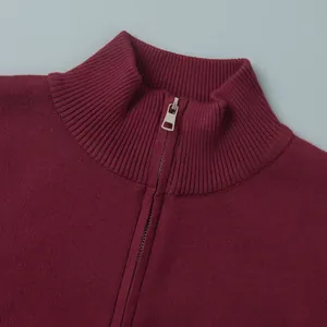 Close-up detail of burgundy knitted sweater with ribbed high collar and metal zipper