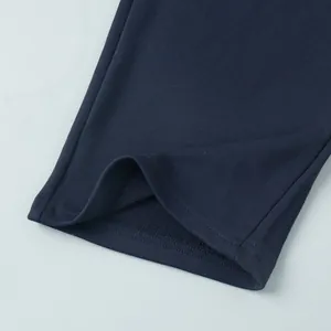 Close-up of navy blue sweatshirt hem showing high-quality stitching and fabric texture.