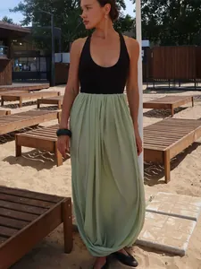 Détail extérieur d'une jupe longue tulipe plissée vert clair pour un look d'été léger