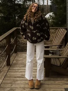 Woman wearing a dark brown floral fleece pullover sweatshirt in a cozy outdoor setting