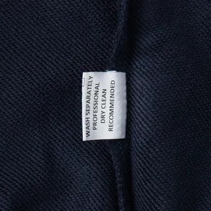 Macro detail view of the laundry care label on a navy blue embroidered sweatshirt set