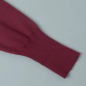 Detailed macro view showing the fine ribbed cuff texture of a maroon knitted sweater