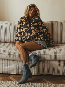 Model wearing an oversized dark grey floral fleece sweatshirt with a half-zip detail