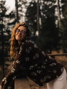 Close-up of floral fleece pullover worn outdoors in a forest setting