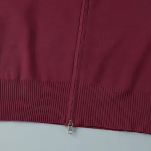 Detailed close-up showing the burgundy ribbed hem and metal zipper on a slim fit knitted sweater