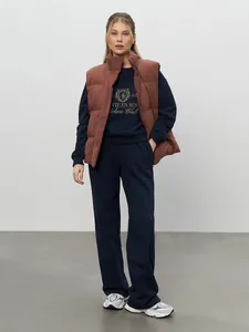 Detail view of navy blue embroidered tracksuit with brown puffer vest for casual autumn style.