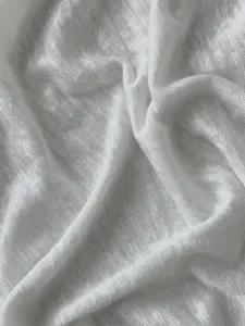Macro detail of white semi-transparent knitted fabric showing texture and folds.