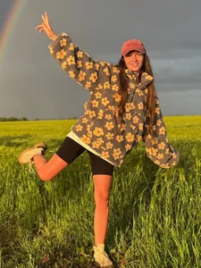 Cozy grey fleece floral hoodie for women in a scenic outdoor setting under a rainbow.
