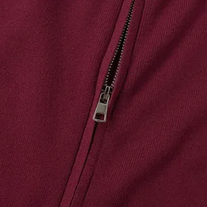 Detailed macro view of high-quality metal zipper on burgundy rib-knit texture sweater
