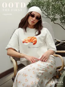 Dettaglio della maglietta in cotone bianco da donna con stampa realistica di un croissant