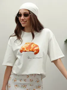 T-shirt da donna in cotone bianco con grafica di croissant e testo in francese
