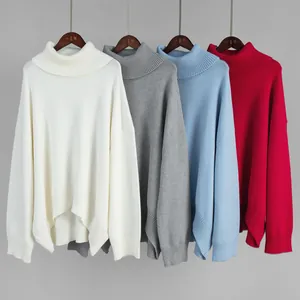 Close-up showing the varied colors of loose turtleneck knitted sweaters on hangers