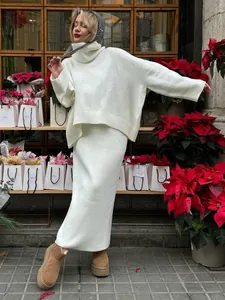 Full view of white loose turtleneck sweater and matching long knit skirt set