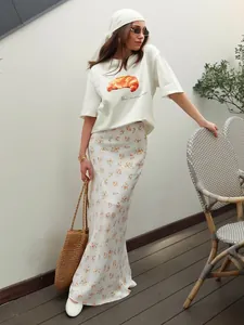 Vista dettagliata della T-shirt in cotone bianco con stampa grafica a cornetto
