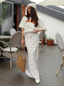 Modella che indossa una maglietta di cotone larga con stampa croissant in un caffè aperto.