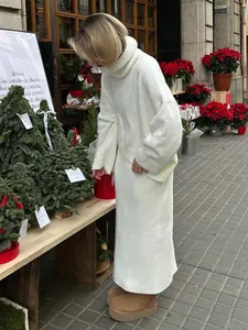 Elegant white turtleneck sweater and matching long knit skirt set in a street scene