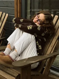 Close-up of a cozy brown floral sherpa fleece hoodie worn in a relaxed outdoor setting