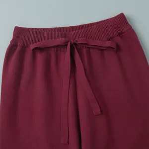 Close-up of burgundy knitted waistband with ribbed texture and drawstring bow detail
