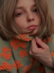 Close-up of olive green fleece sweatshirt with fuzzy orange flower pattern detail
