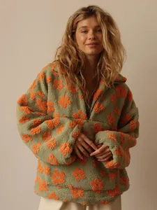 Detailed view of model wearing a green floral fleece hoodie with orange flower patterns